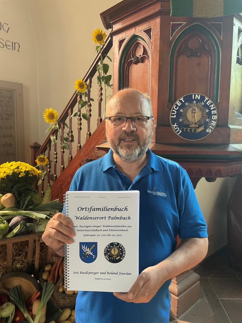 Roland Jourdan mit dem neuen Ortsfamilienbuch in der Waldenserkirche Palmbach